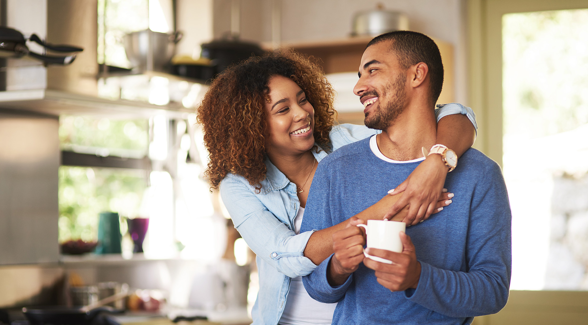 Couple smiling at each other in their kitchen at home.